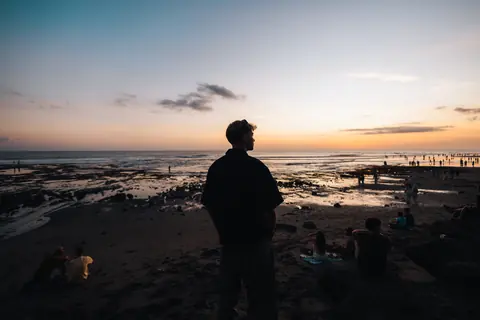 Malakai on the beach at sunset, the tide out