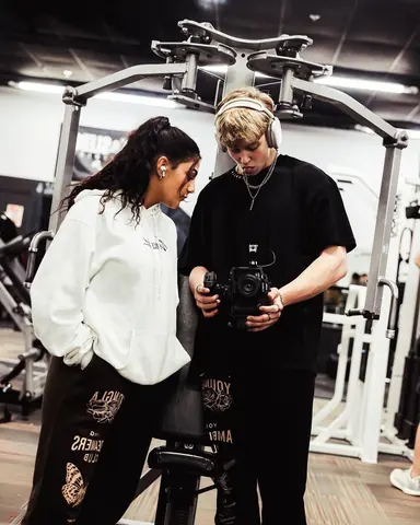 Malakai showing Maddie a shot on his camera in a gym