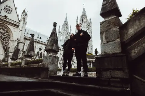 Malakai and Maddie on a ledge of a gothic basilica