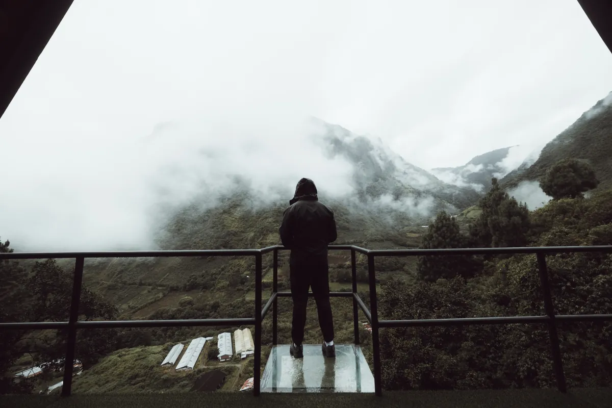 Malakai on a viewing platform above clouds and mountains