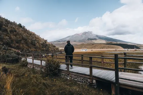 Malakai on a boardwalk looking toward a volcano