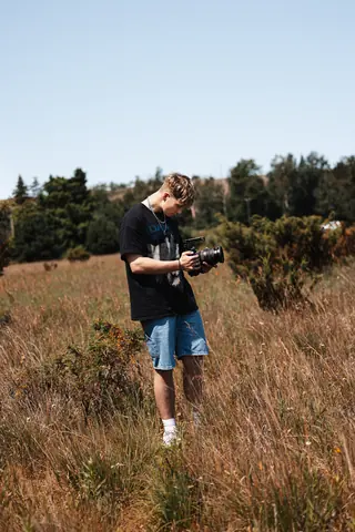 Malakai filming in a field of long grass