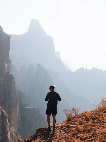 Malakai silhouetted on a cliff among rock spires in the Gheralta mountains