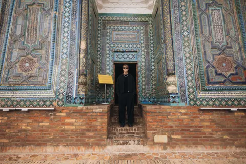 Malakai in a tiled doorway covered in blue mosaic