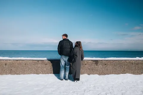 The two of them at a sea wall on a snowy coast