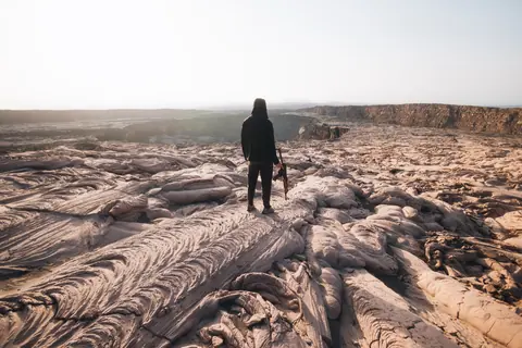 Malakai walking across sculpted lava fields