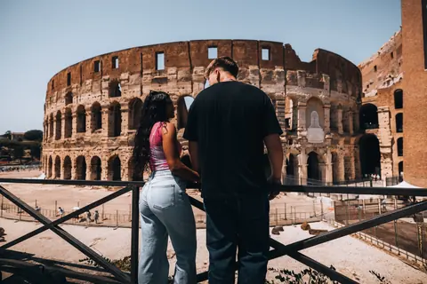 Malakai and Maddie at a railing looking at the Colosseum
