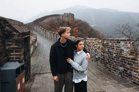 Malakai and Maddie arm in arm on the Great Wall