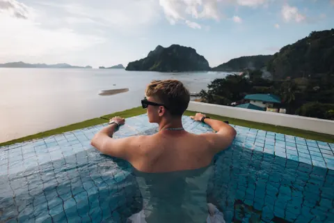Malakai in an infinity pool looking out over islands